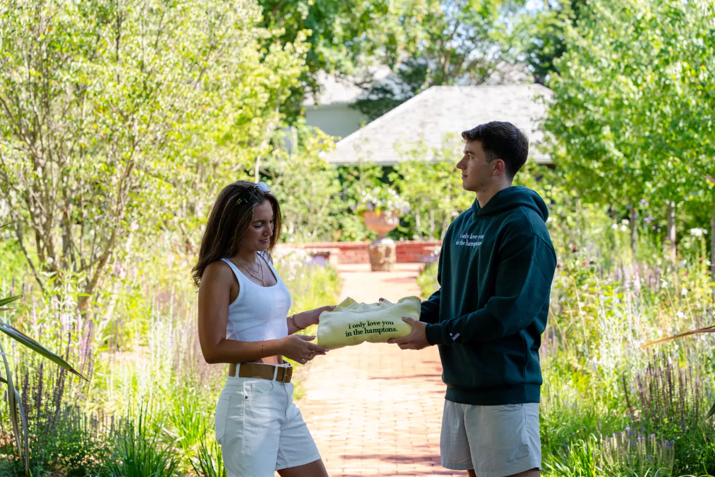 Two friends passing a bag in the garden